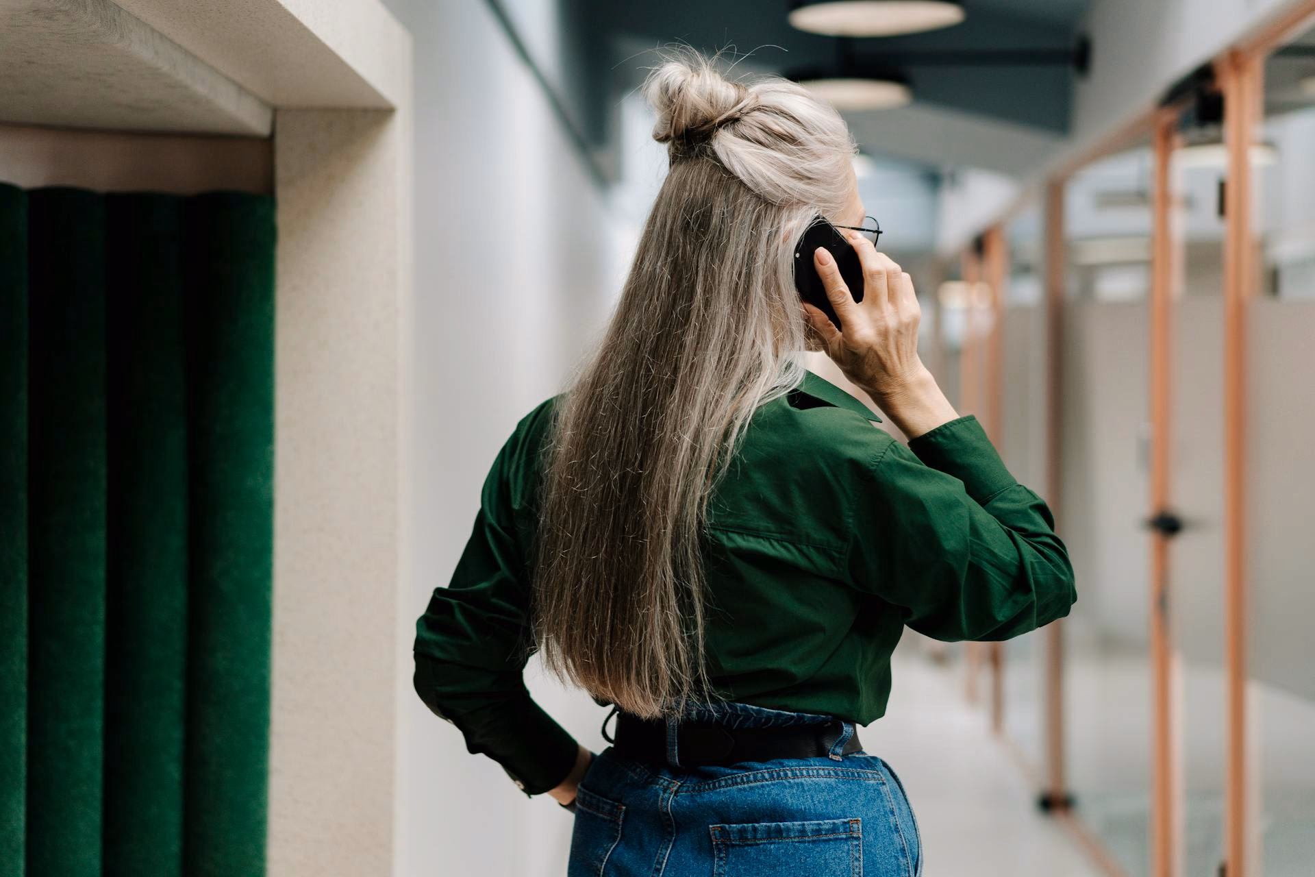 Vrouw belt in een lichte gang